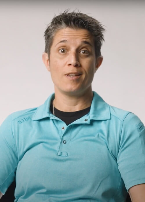 A headshot of a women in a blue collared shirt