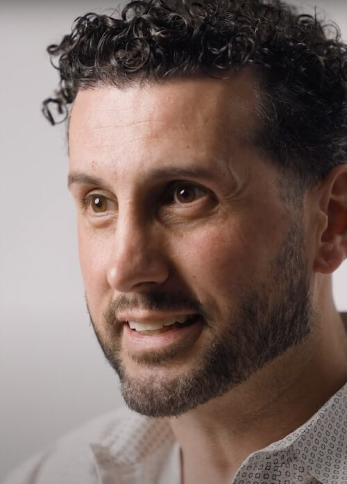 A headshot of a man in a white shirt